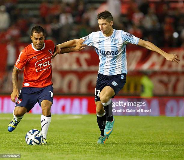 Daniel Montenegro of Independiente drives the ball as he is chased by Gaston Campi of Racing Club during a match between Racing Club and...