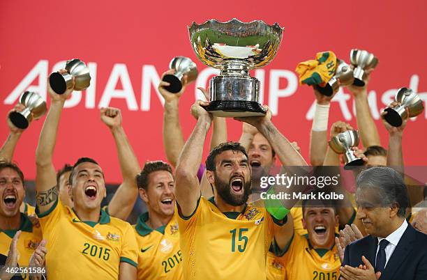 Mile Jedinak of Australia and his team celebrate as he lifts the trophy after victory during the 2015 Asian Cup final match between Korea Republic...