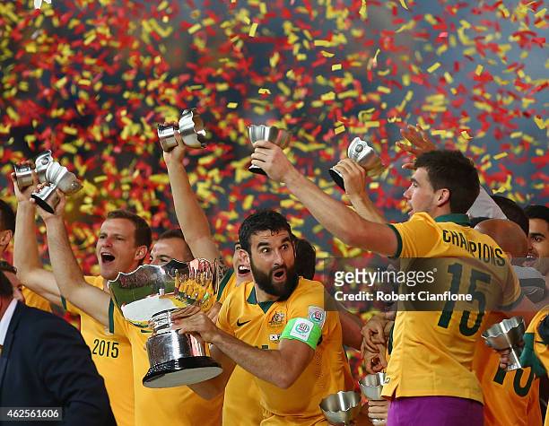 Mile Jedinak of Australia celebrates with the winners trophy after Australia defeated Korea republic at the 2015 Asian Cup final match between Korea...
