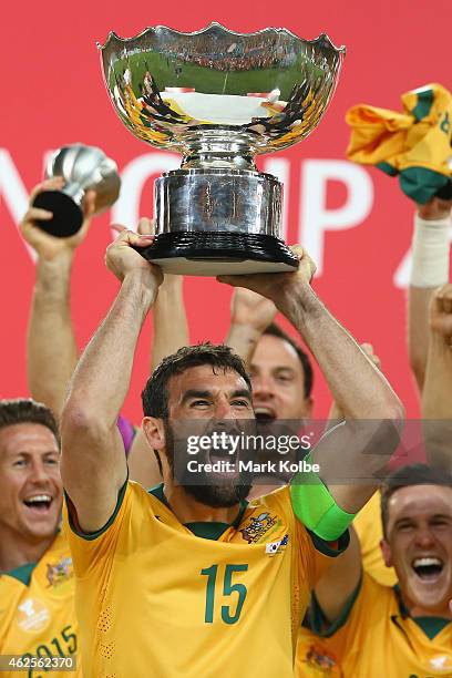 Mile Jedinak of Australia celebrates as he lifts the trophy after victory during the 2015 Asian Cup final match between Korea Republic and the...