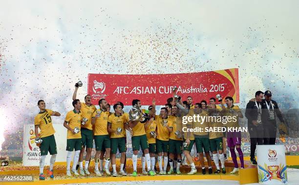 Australia's captain Mile Jedinak holds the AFC Asian Cup football trophy after beating South Korea at Stadium Australia in Sydney on January 31,...