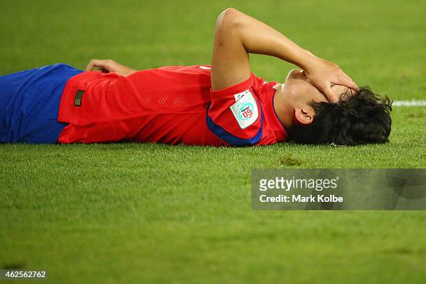 Son Heung Min of Korea Republic lies on the ground dejected after defeat during the 2015 Asian Cup final match between Korea Republic and the...