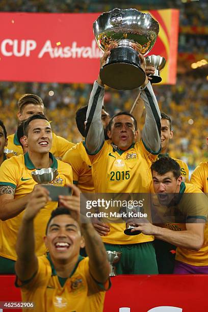 Jason Davidson, Tim Cahill and Mathew Ryan of Australia celebrate with the trophy as Massimo Luongo of Australia takes a selfie during the 2015 Asian...