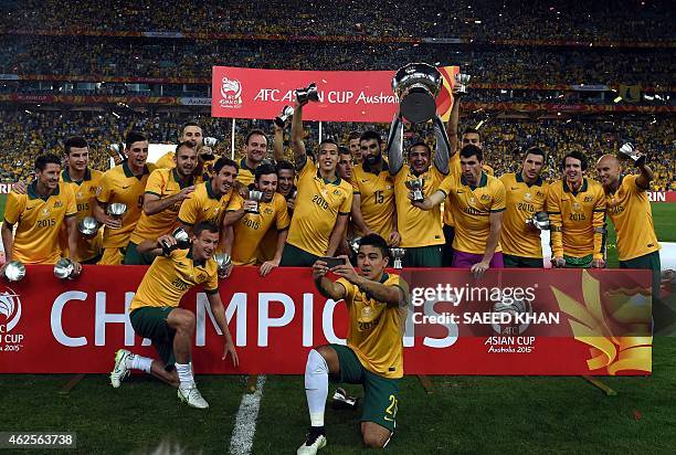 Australia's Tim Cahill and teammates celebrate with the AFC Asian Cup football trophy after beating South Korea at Stadium Australia in Sydney on...