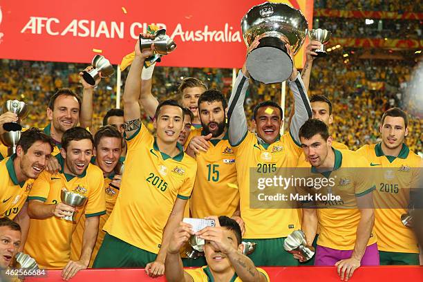 The Australian team celebrate with the trophy as Massimo Luongo of Australia takes a selfie during the 2015 Asian Cup final match between Korea...