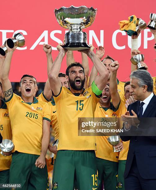 Australia's Mile Jedinak celebrates as he lifts the trophy after beating South Korea in the AFC Asian Cup football final at Stadium Australia in...