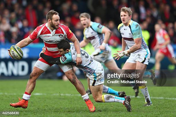 Bill Meakes of Gloucester looks for support as Tom Habberfield of Ospreys holds on during the LV=Cup match between Gloucester Rugby and Ospreys at...
