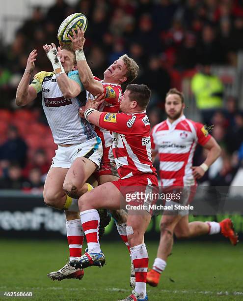 Ben John of Ospreys loses out to a high ball alongside Steph Reynolds and Darren Dawidiuk of Gloucester of Ospreys during the LV=Cup match between...