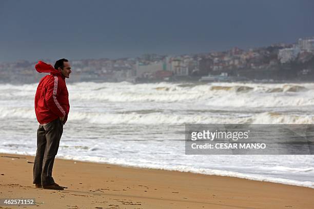 Man looks at waves at Somo beach, near Santander, on January 31, 2015. Fierce waves were pounding seafronts and fishing boats off northern Spain,...