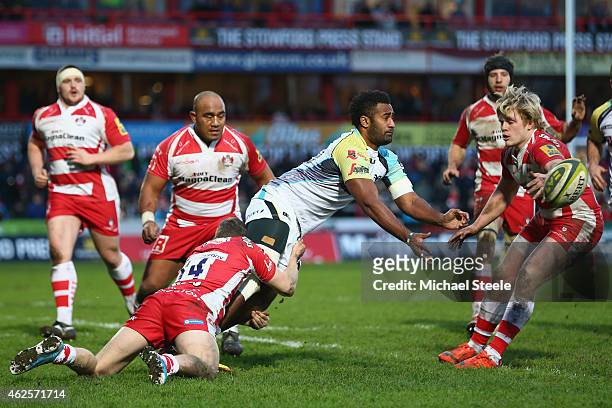 Aisea Natoga of Ospreys passes under pressure from Steph Reynolds and Dan Thomas of Gloucester during the LV=Cup match between Gloucester Rugby and...