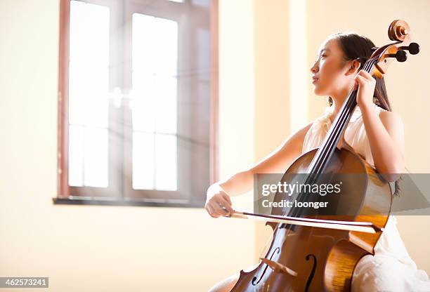 est asiatica adolescente ragazza suona violoncello - violoncellista foto e immagini stock