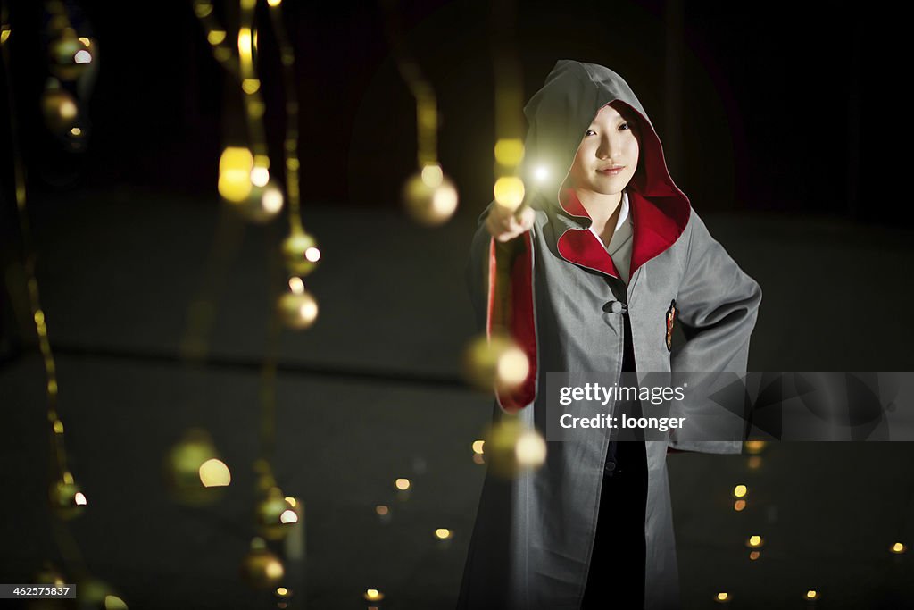 Young girl casting a spell with magic wand