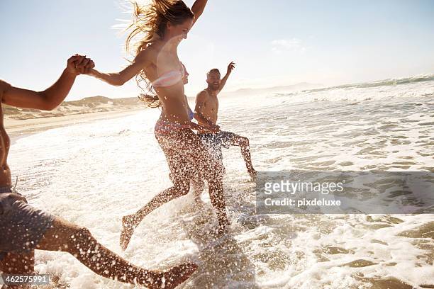 splashing through the waves - beach stock pictures, royalty-free photos & images