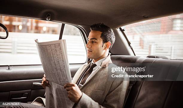 businessman on a yellow cab reading newspaper - man in car reading newspaper stock pictures, royalty-free photos & images