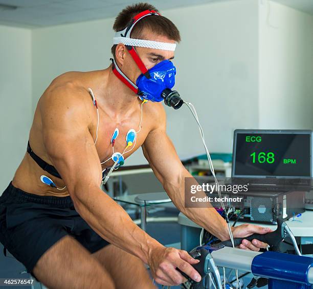 male athlete performing ecg and vo2 test on indoor bicycle - cardiopulmonary system stock pictures, royalty-free photos & images