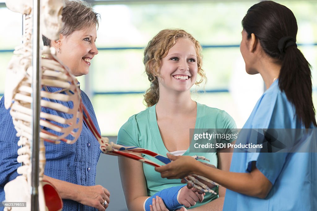 Krankenschwester oder Physiotherapeutin Verletzungen teen Patienten zu erklären,