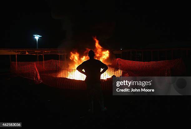 Doctors Without Borders , staffer Alex Eilert Paulsen watches as mattresses and bed frames burn at the Ebola Treatment Unit , on January 31, 2015 in...