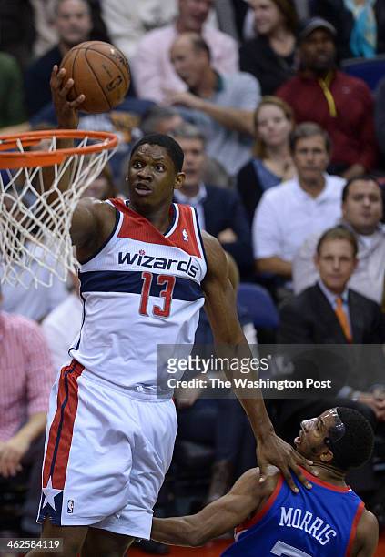 Washington Wizards center Kevin Seraphin goes up over Philadelphia 76ers point guard Darius Morris for a basket during the home opener between the...
