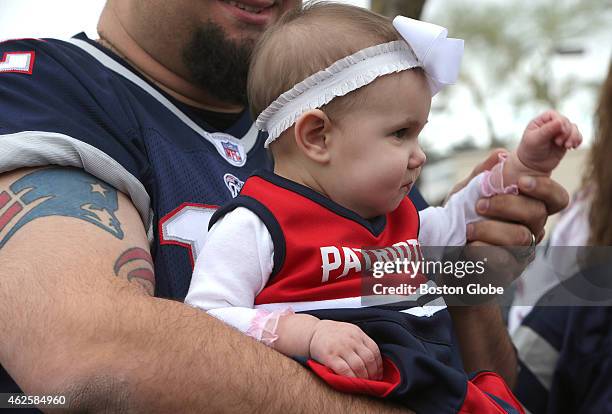 Scarlett, 8 months, is nestled snuggly in the arms of her father, Patriots fan Harry Skigis, at a Patriots fan rally at Toso's Sports Bar & Grill.