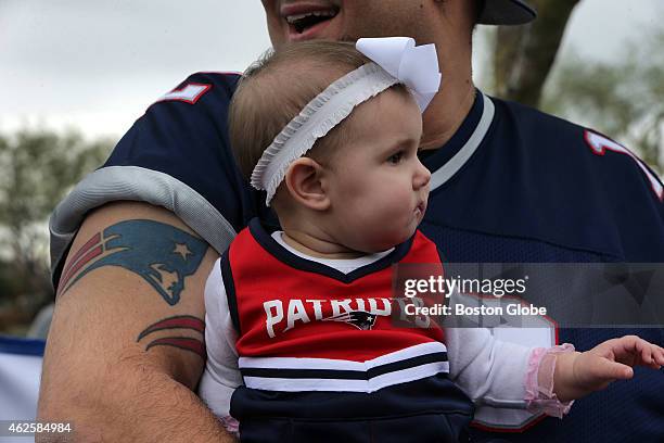 Scarlett, 8 months, is nestled snuggly in the arms of her father, Patriots fan Harry Skigis, at a Patriots fan rally at Toso's Sports Bar & Grill....