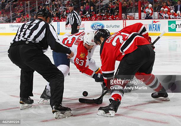 Linesman Jay Sharrers drops the puck on a faceoff between Dave Bolland of the Florida Panthers and Scott Gomez of the New Jersey Devils during the...