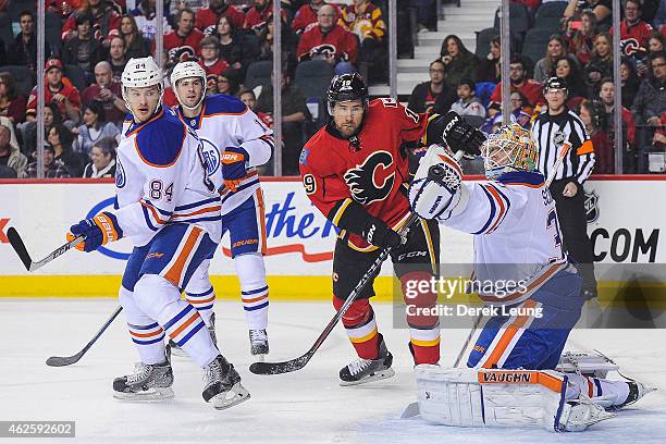 Ben Scrivens of the Edmonton Oilers makes a save in front of David Jones of the Calgary Flames during an NHL game at Scotiabank Saddledome on January...