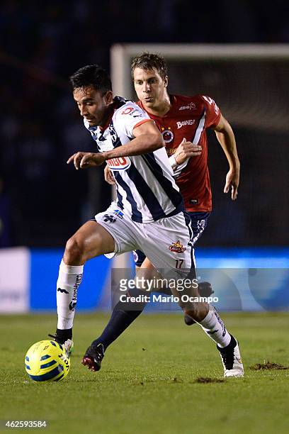 Jesus Zavala of Monterrey runs with the ball as Julio Furch of Veracruz tries to reach him during a match between Monterrey and Veracruz as part of...