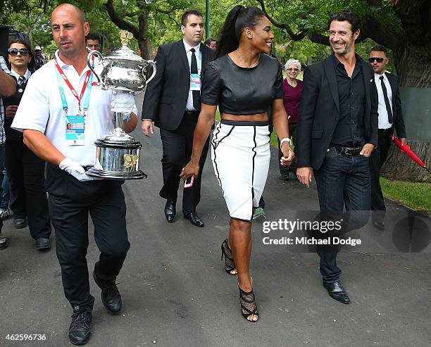 Serena Williams of the United States leaves with her partner and coach Patrick Mouratoglou and the Daphne Akhurst Memorial Cup during a photocall at...