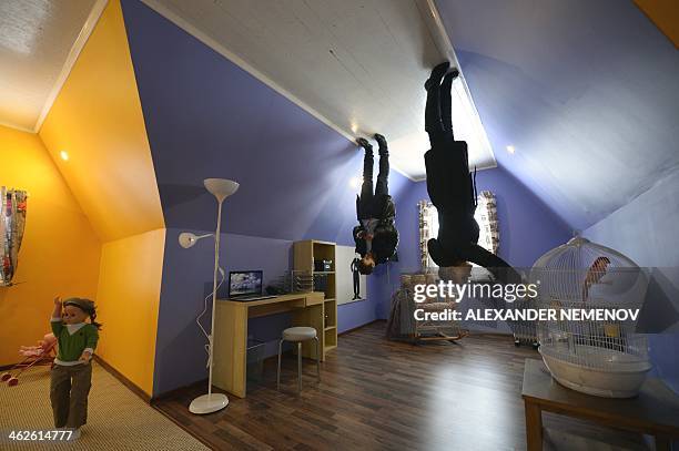 Picture rotated 180 degrees shows visitors walking inside an "upside-down house" attraction at the VVTs the All-Russia Exhibition Center in Moscow,...