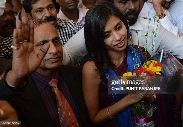 Indian diplomat Devyani Khobragade , accompanied by her father Uttam Khobragade, gives a traditional greeting on her arrival at the domestic airport...