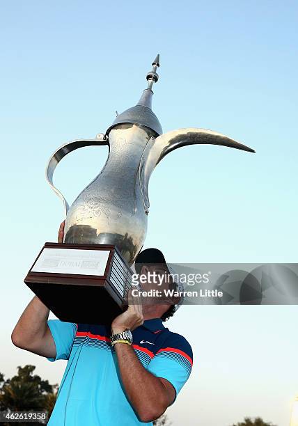 Rory McIlroy of Northern Ireland raises the trophy after winning the Omega Dubai Desert Classic on the Majlis Course at the Emirates Golf Club on...