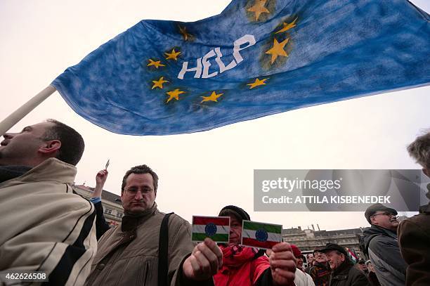 Protesters hold an EU flag in front of the building of the parliament in Budapest downtown on February 1, 2015 during their anti-government...