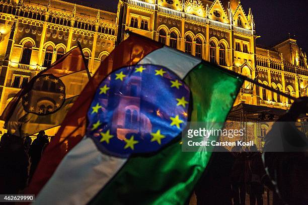 Protesters wave flags with a combination with the Hungarian national colors and the symbol of the European Union as several thousand protesters...