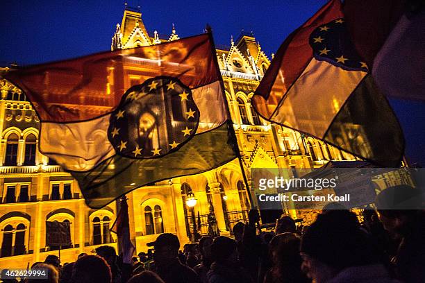 Protesters wave flags with a combination with the Hungarian national colors and the symbol of the European Union as several thousand protesters...
