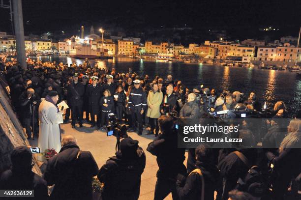 Island residents take part in a candlelight vigil before holding a minute of silence to mark the exact time that the Costa Concordia ship crashed on...