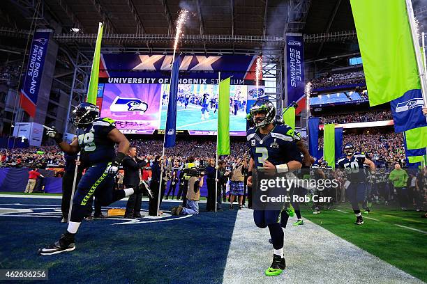 Russell Wilson of the Seattle Seahawks runs onto the field with his teammates prior to Super Bowl XLIX against the New England Patriots at University...