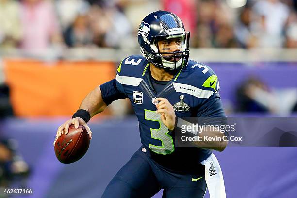 Russell Wilson of the Seattle Seahawks looks to pass in the first quarter against the New England Patriots during Super Bowl XLIX at University of...