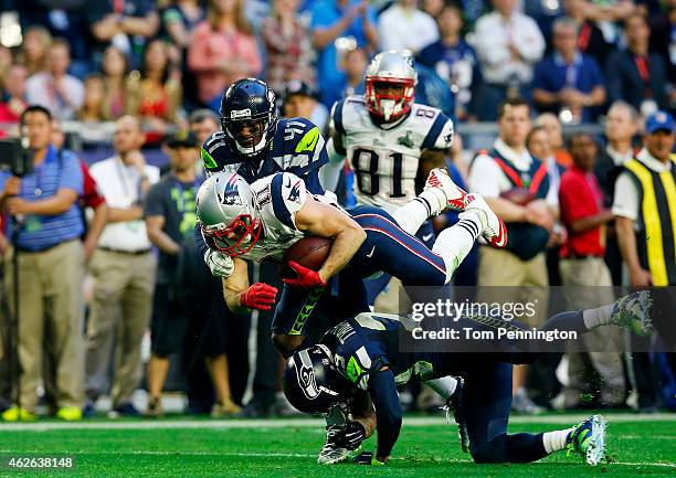 Julian Edelman of the New England Patriots is tacked by Byron Maxwell and Earl Thomas of the Seattle Seahawks in the second quarter during Super Bowl...