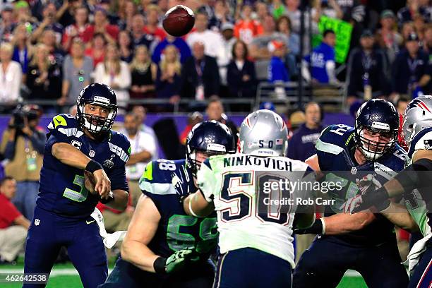 Russell Wilson of the Seattle Seahawks has a pass intercepted by Malcolm Butler of the New England Patriots late in the fourth quarter against the...