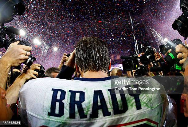 Tom Brady of the New England Patriots is surrounded by the media after defeating the Seattle Seahawks 28-24 during Super Bowl XLIX at University of...