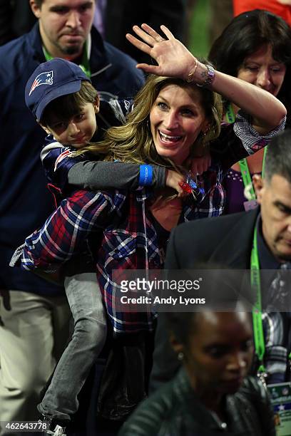 Gisele Bundchen, wife of Tom Brady of the New England Patriots, walks on the field with their son, Benjamin after defeating the Seattle Seahawks...