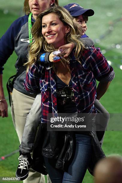 Gisele Bundchen, wife of Tom Brady of the New England Patriots, walks on the field with their son, Benjamin after defeating the Seattle Seahawks...