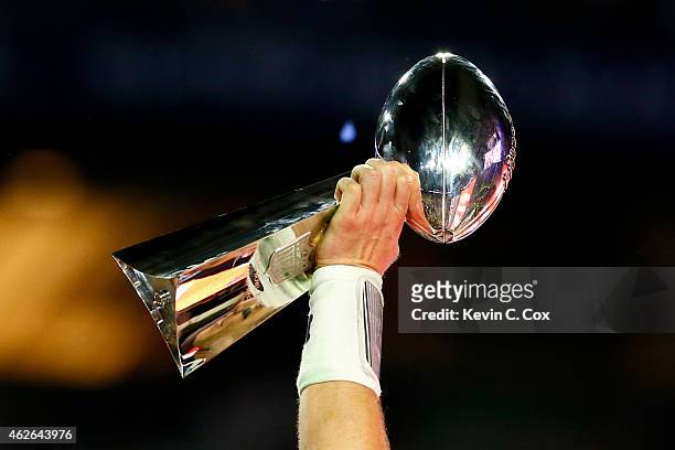 Tom Brady of the New England Patriots celebrates holding the Vince Lombardi Trophy after defeating the Seattle Seahawks during Super Bowl XLIX at...