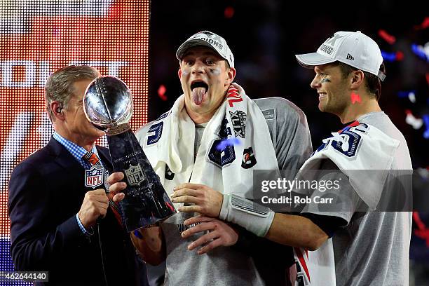 Rob Gronkowski of the New England Patriots celebrates while holding up the Vince Lombardi Trophy after defeating the Seattle Seahawks as Tom Brady...