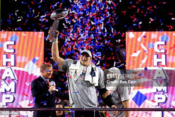 Rob Gronkowski of the New England Patriots celebrates while holding up the Vince Lombardi Trophy after defeating the Seattle Seahawks as TV...