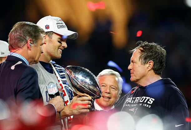 Tom Brady, team owner Robert Kraft, and head coach Bill Belichick of the New England Patriots celebrate with the Vince Lombardi Trophy after...