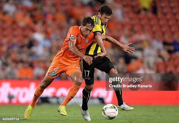 Adam Sarota of the Roar and Vince Lia of Wellington Phoenix challenge for the ball during the round 16 A-League match between the Brisbane Roar and...