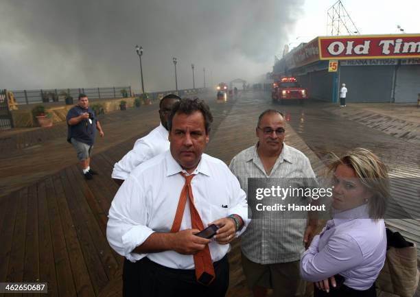 In this handout provided by the Office of the Governor Of N.J., Governor Chris Christie tours the fire area with Deputy Chief of Staff Bridget Anne...