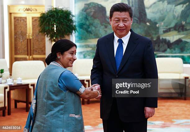 Indian Foreign Minister Sushma Swaraj and Chinese President Xi Jinping face the media as they greet each other before starting a meeting at the Great...