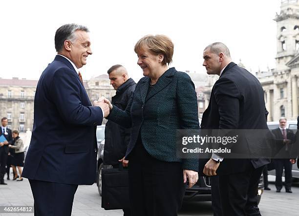 Hungary's prime minister Viktor Orban welcomes German Chancellor Angela Merkel during Merkel's official visit in front of the Parliament building in...